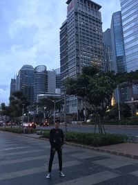 Full length of man and buildings in city against sky