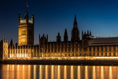 Illuminated buildings in city against sky at night