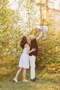 A happy family with one small child walking together in the park in the summer outdoors