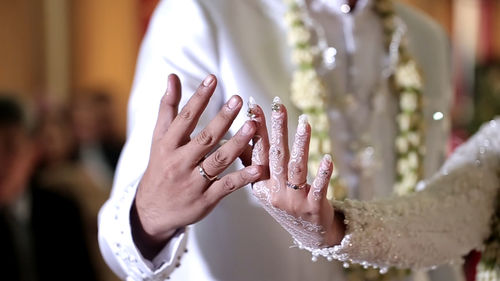 Midsection of woman holding hands against blurred background