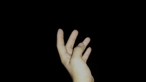 Close-up of hand over black background