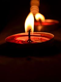 Close-up of illuminated tea light in darkroom