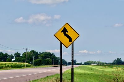 Road sign against sky