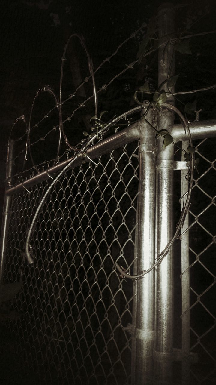 night, metal, safety, security, protection, illuminated, built structure, fence, metallic, close-up, low angle view, architecture, pattern, old, no people, closed, outdoors, building exterior, gate, dark