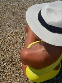 Rear view of woman in bikini wearing hat on beach