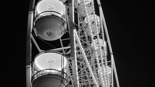 Low angle view of illuminated carousel against sky at night