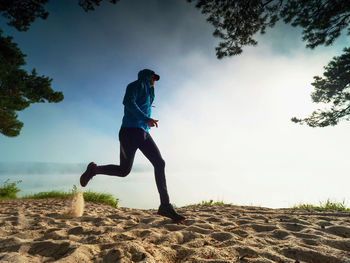 Male runner run hard in white sand of beach during morning workout. regular condition training