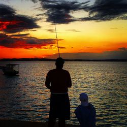 Silhouette of man fishing in sea