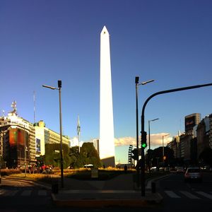 Cars on road against clear blue sky