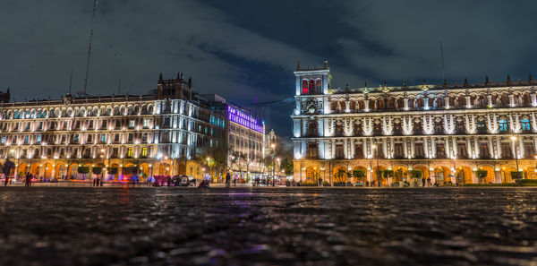 Illuminated historic buildings in city against sky at night