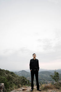 Full length of man standing on mountain against sky