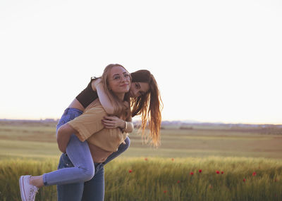 Two women holding hands at sunset in the field