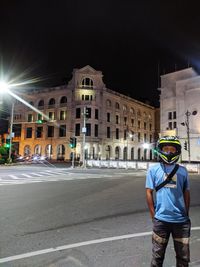 Man standing on road at night