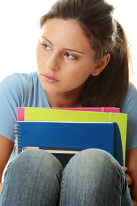 Portrait of young woman sitting on book