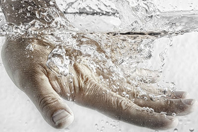 Close-up of cropped hand in water