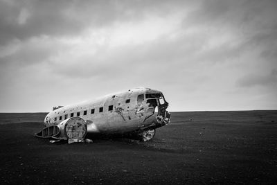 Abandoned airplane on airport runway against sky