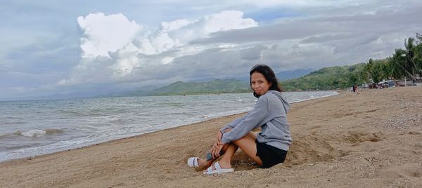 Portrait of young woman sitting on beach