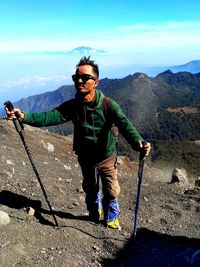 Portrait of man standing on mountain against sky