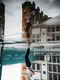 Reflection of man in city against sky