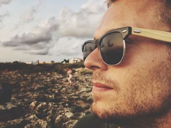Close-up of young man wearing sunglasses against sky