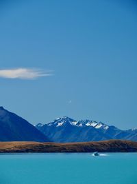 Scenic view of snowcapped mountains against blue sky