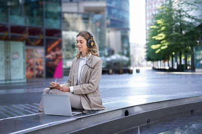 Young woman using mobile phone in city