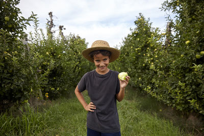 Young farmer picking apples from the trees