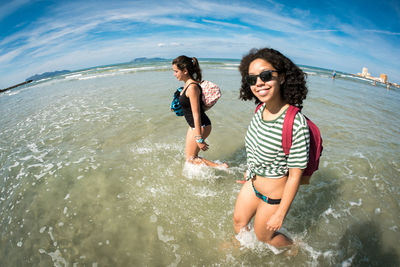 Full length of happy friends enjoying on beach