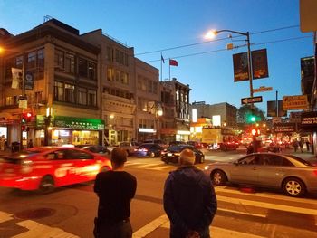 People walking on city street at night