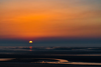 Scenic view of sea against orange sky