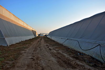 Road amidst land against clear sky