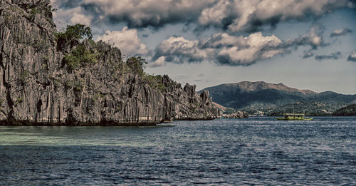 Scenic view of sea and mountains against sky