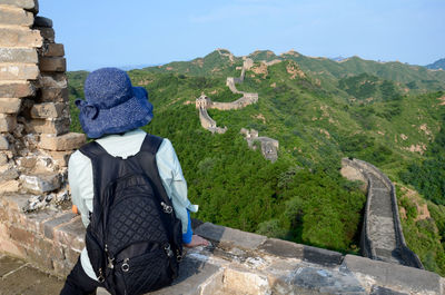 Rear view of woman on rock against sky