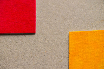 High angle view of red and yellow papers on cardboard