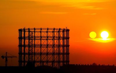 Silhouette crane against sky during sunset