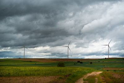 Wide shot of sustainable windmills at a farm field in valdorros in castile and leon, burgos, spain.