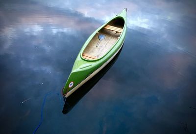 Boat moored on lake against sky