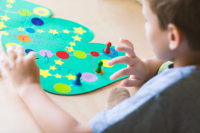 Child rolls the dice and moves the chip across the christmas playing field. plaing board game 