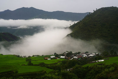 Scenic view of field and mountains against sky