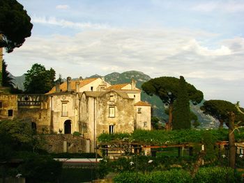 Old building by trees against sky