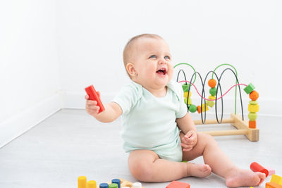 Portrait of cute boy playing with toys against white background