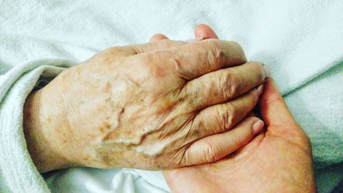 Close-up of hand on bed