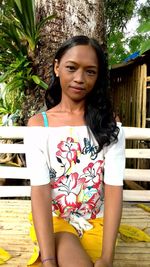 Portrait of young woman sitting outdoors