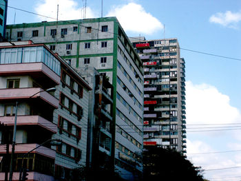 Low angle view of buildings against cloudy sky