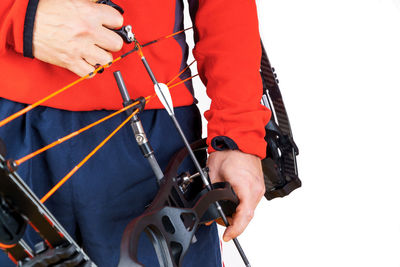 Midsection of archer holding cross bow against white background