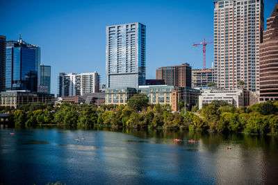 Lake against modern buildings in city