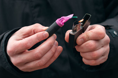 Close-up of man igniting firecracker outdoors