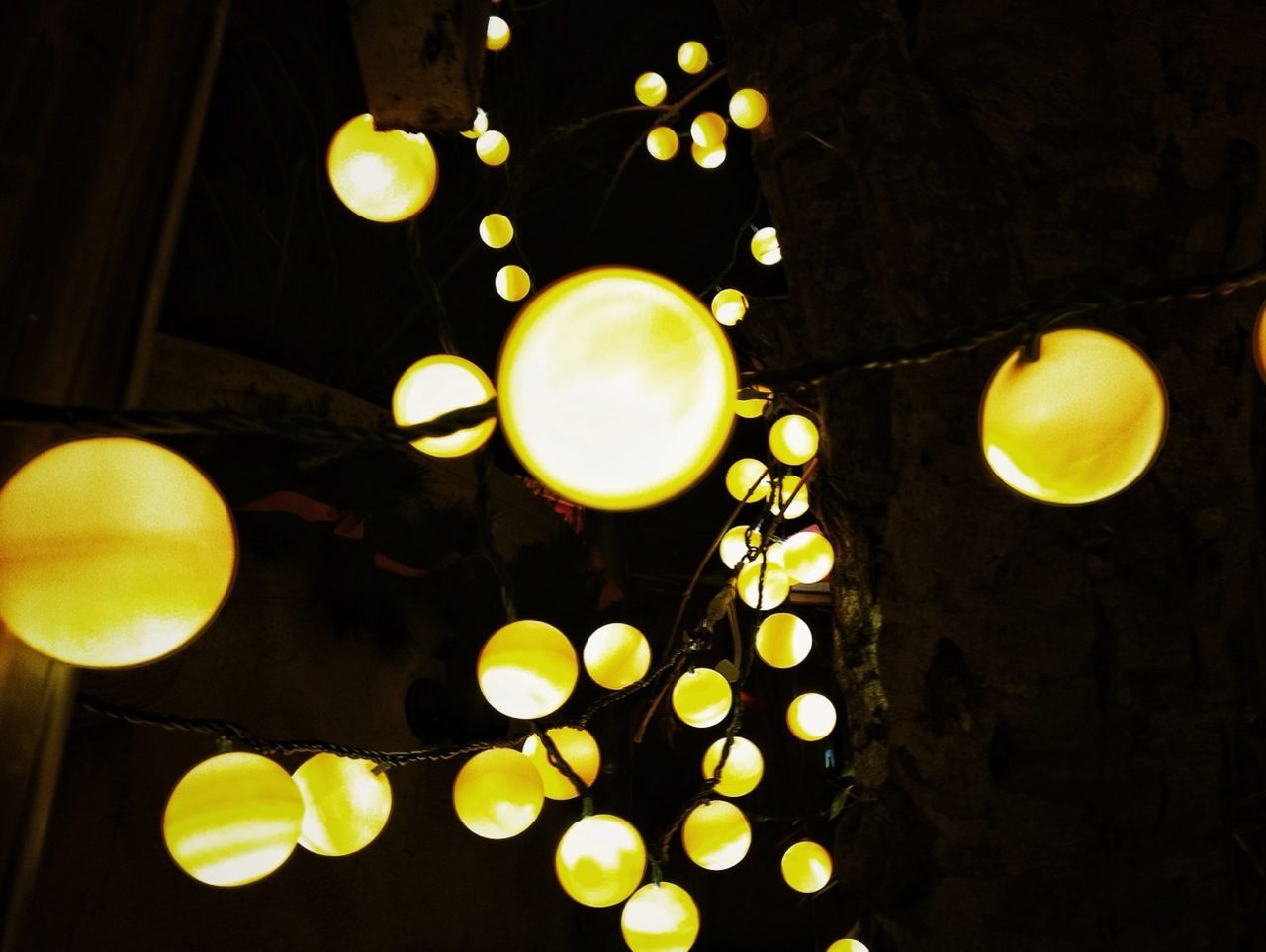 illuminated, lighting equipment, low angle view, indoors, night, hanging, electricity, light bulb, electric lamp, circle, sphere, light - natural phenomenon, close-up, yellow, no people, electric light, decoration, glowing, still life, home interior