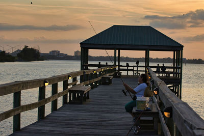 Pier over sea against sky during sunset