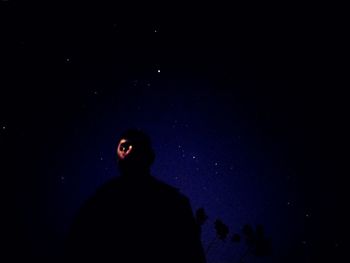 Portrait of silhouette man standing against sky at night